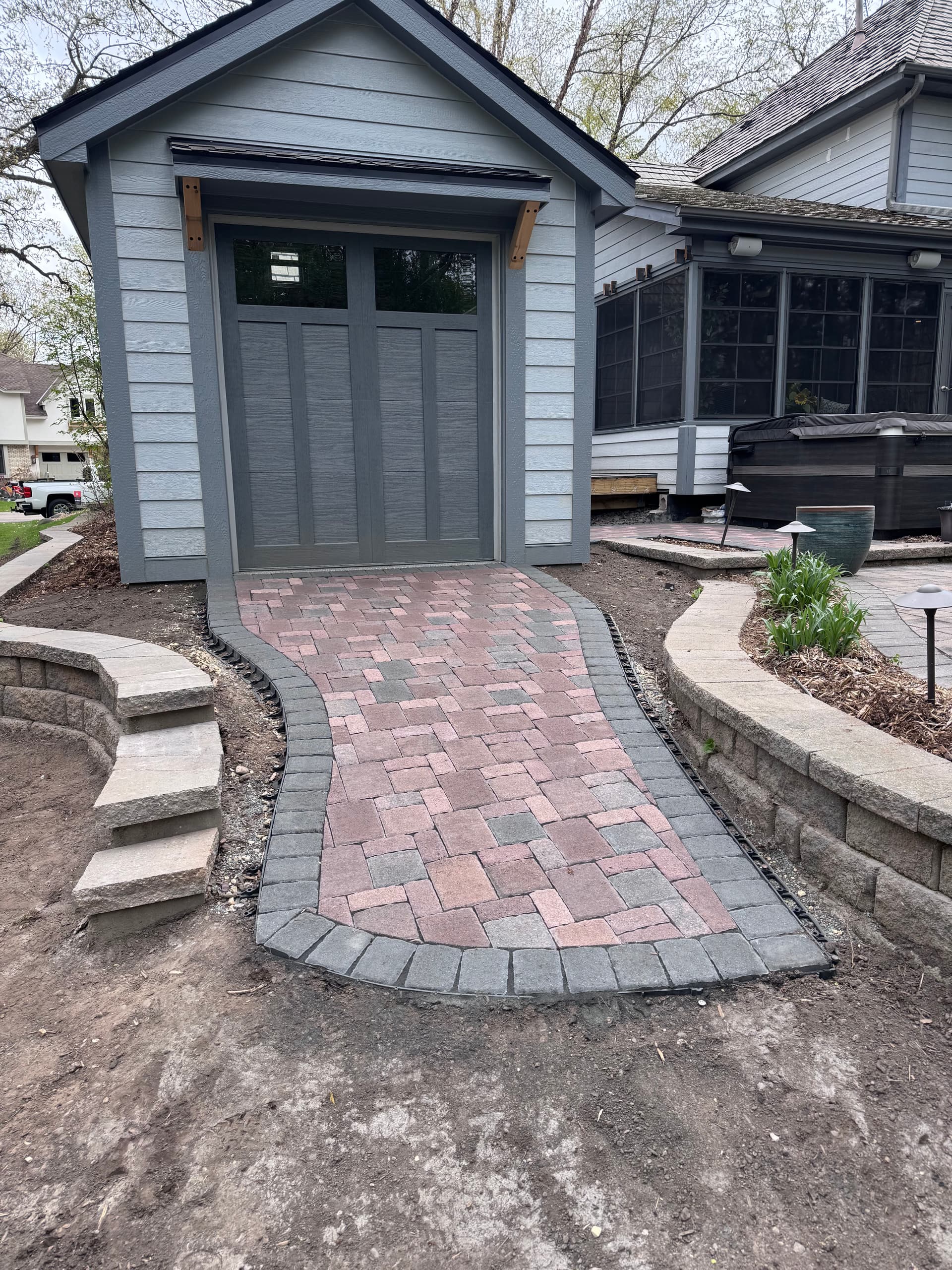 Paver Walkway and Retaining Wall Install Around a Backyard Shed image
